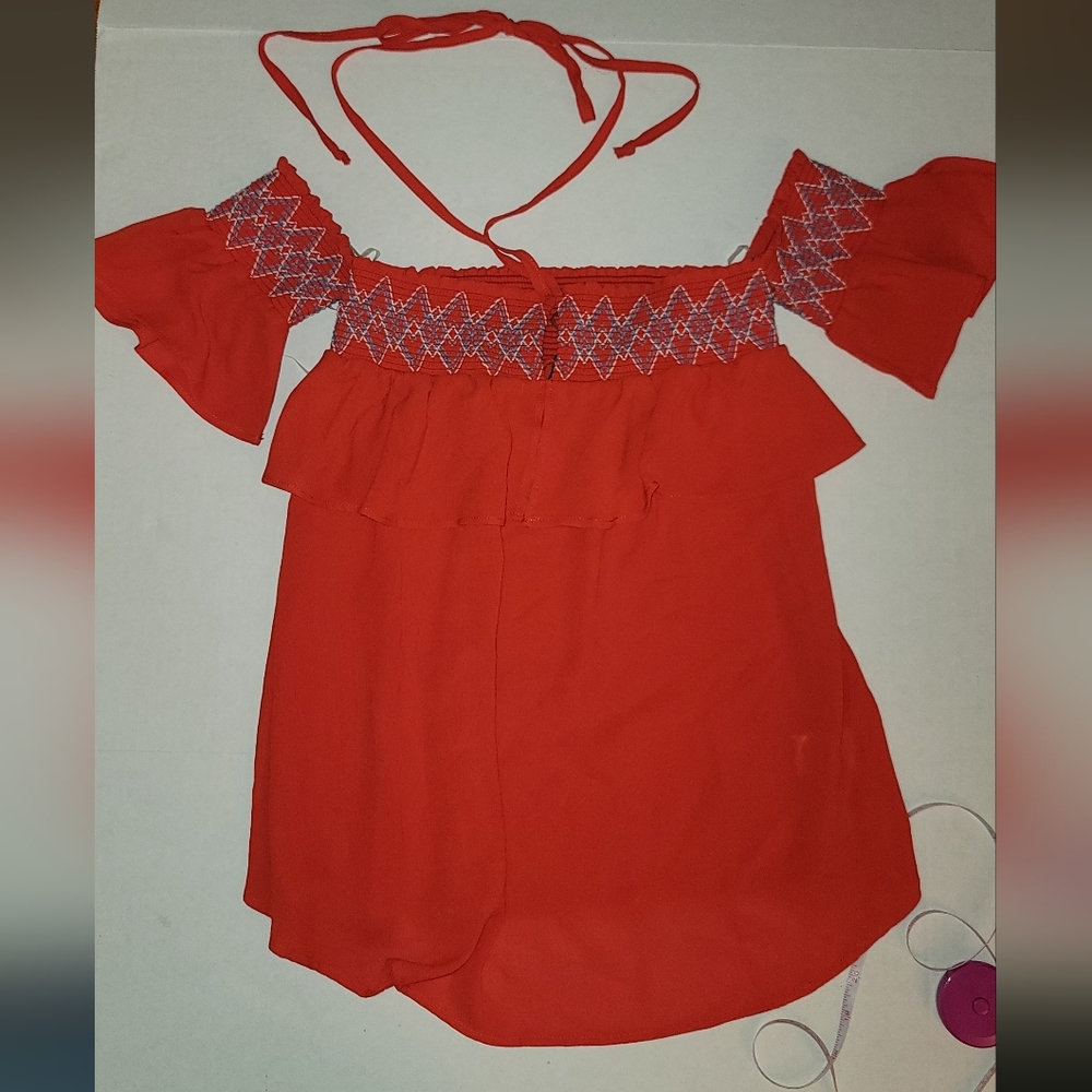 Fun and flirty off shoulder top. Has attached arm bands and tie. Unique